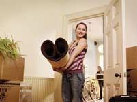Woman holding a carpet while moving house