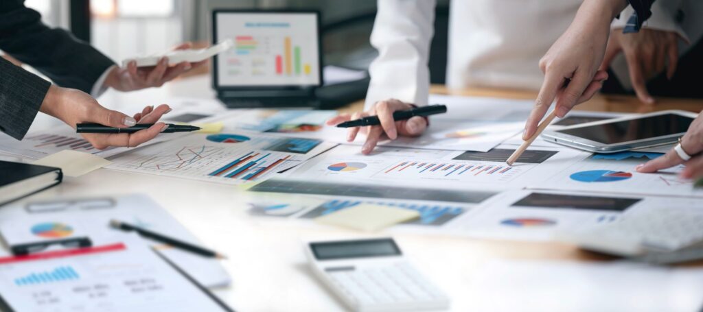 Cropped shot of co-workers working together in boardroom, brainstorming, discussing and analysing business strategy.