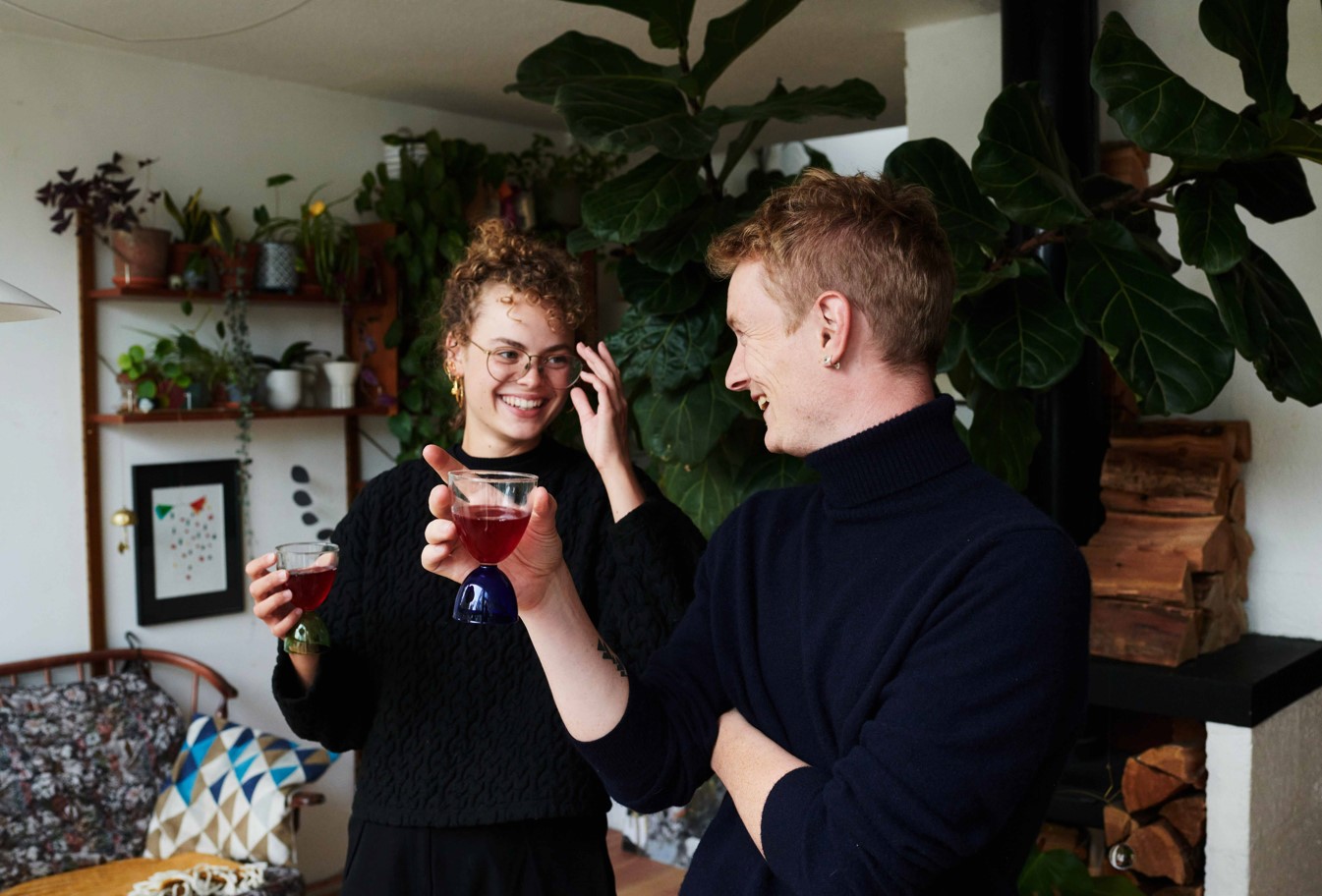 Two people smiling having drinks in their lounge