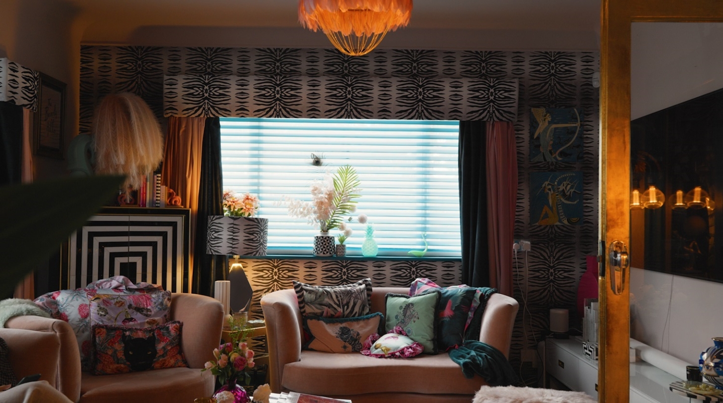 An ornately decorated room, with pink sofas filled with cushions