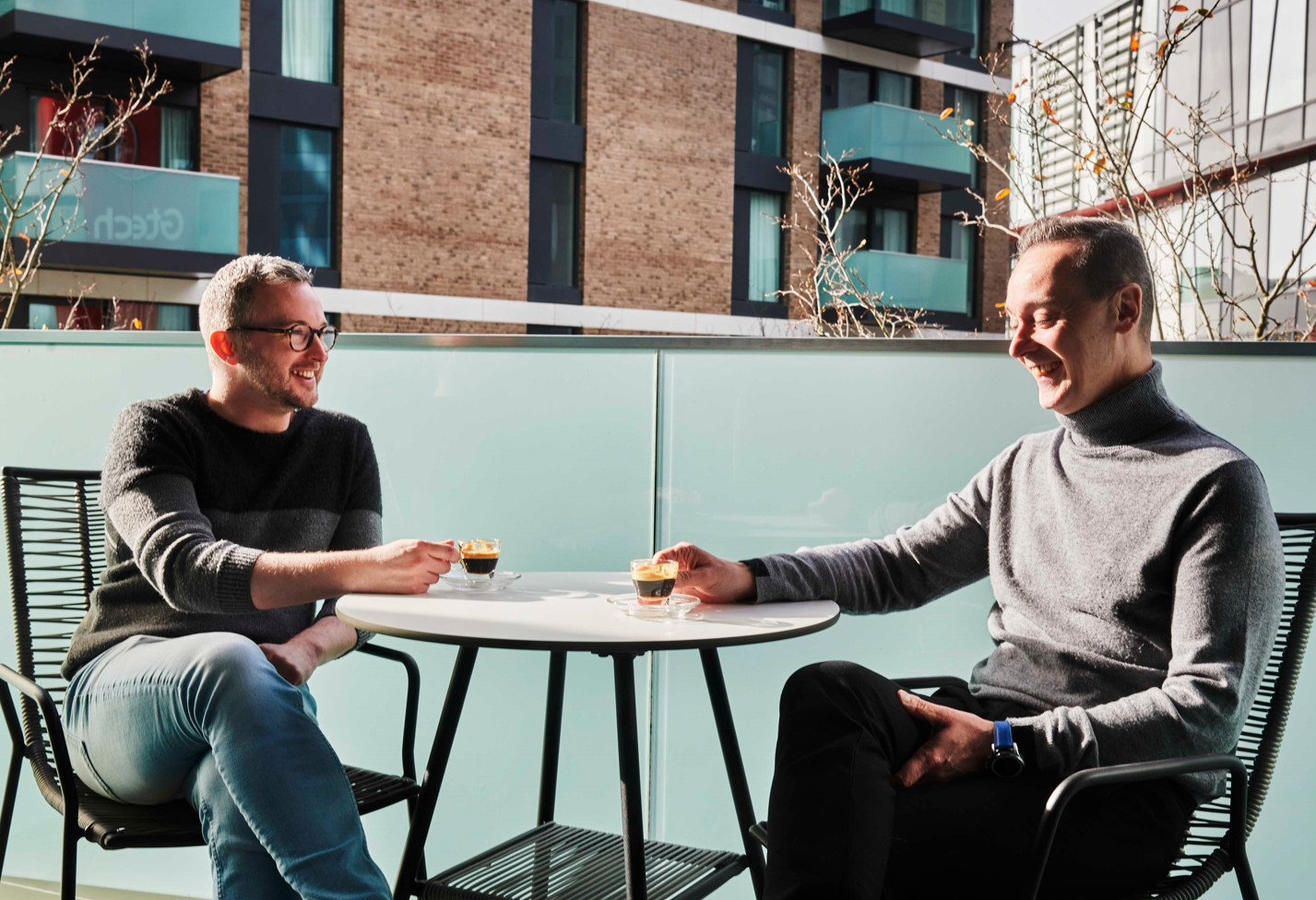 Two people having coffee on a balcony