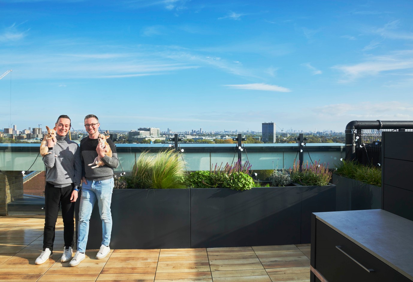Two people on a roof terrace with two dogs, views of London