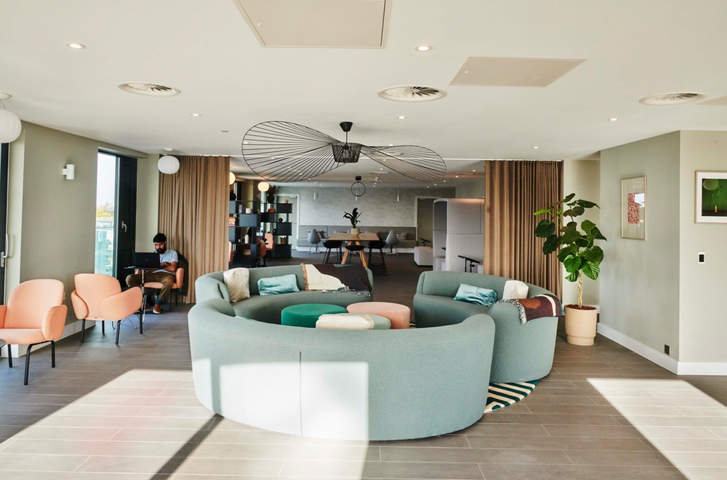 Communal lounge, curved sofas, modern lighting and plants