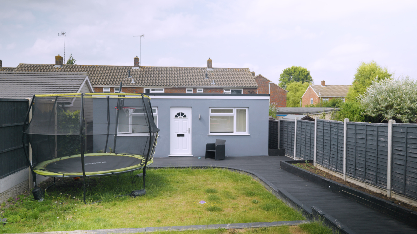 A garden with a trampoline and an annexe