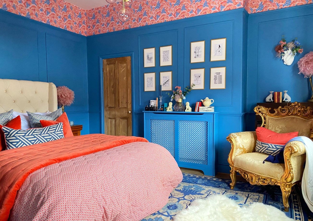 A brightly decorated double bedroom with blue and pink walls