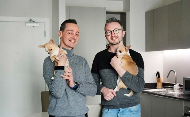 Two people and two dogs in a kitchen