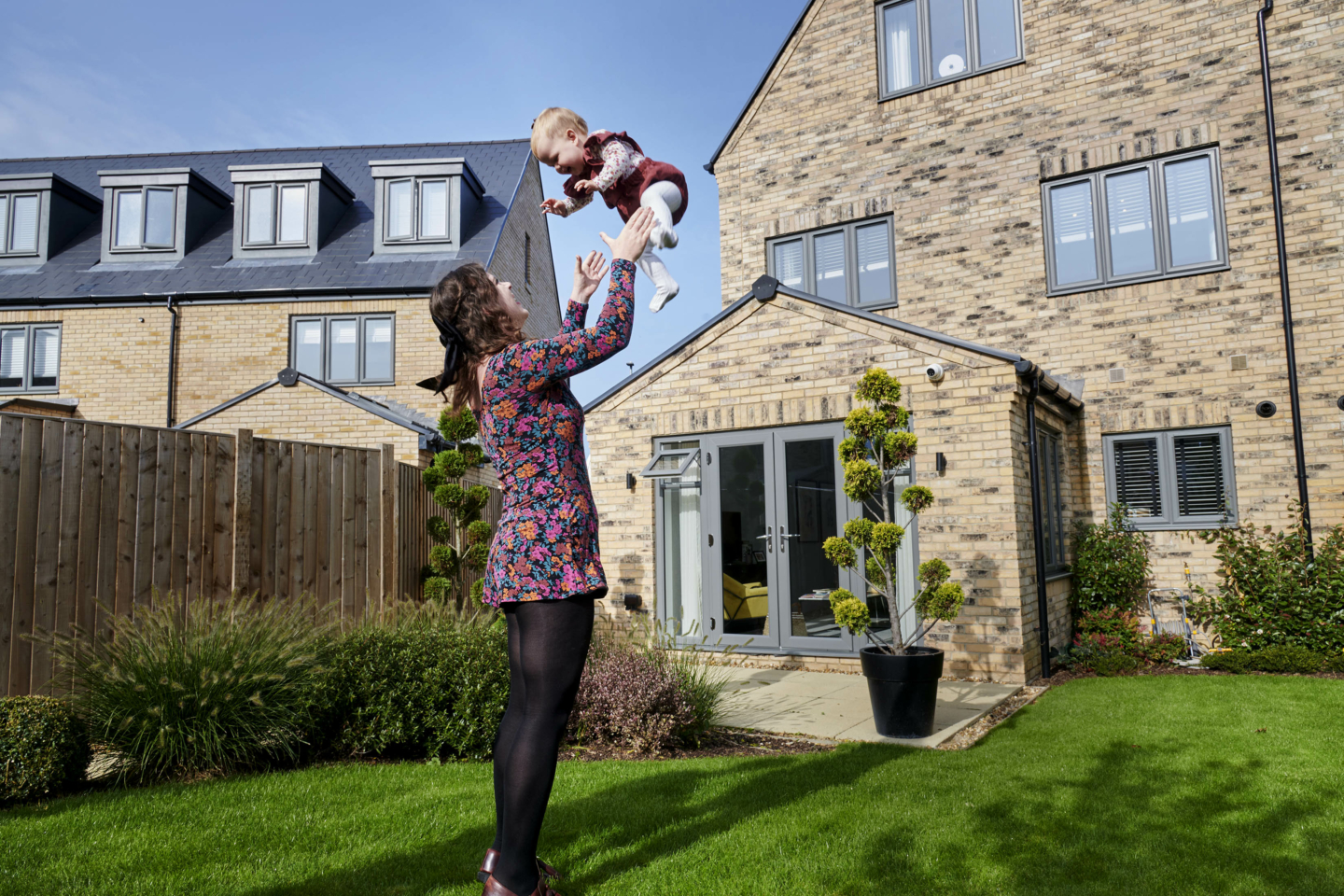 A person with a baby in a garden