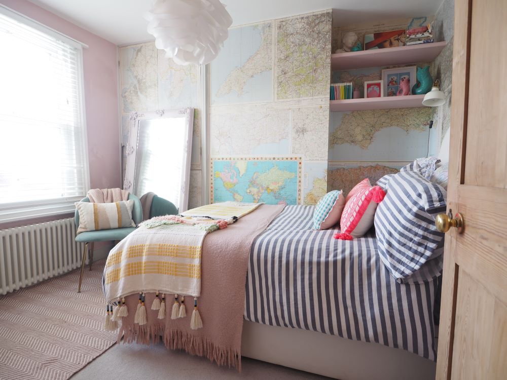 A double bedroom with maps on the walls