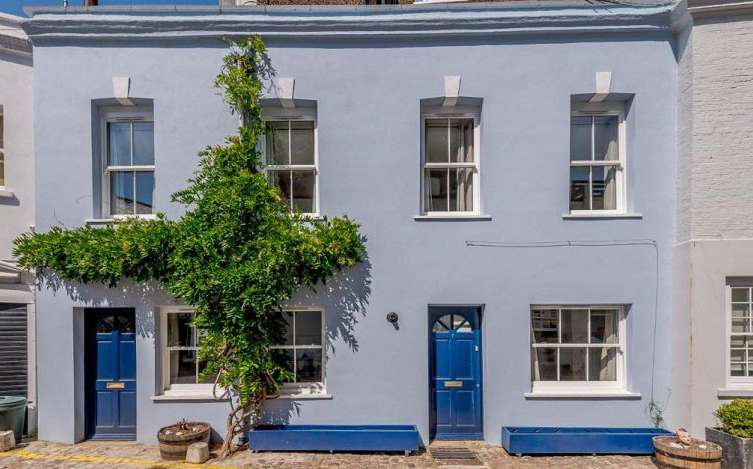 A sky blue mews house with a royal blue front door