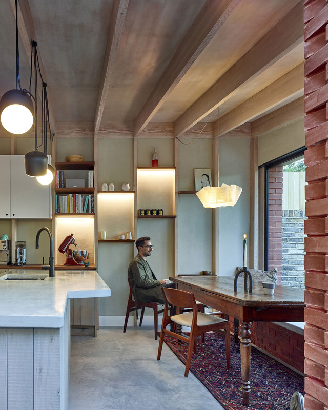 A person sitting at t dining table, in a kitchen