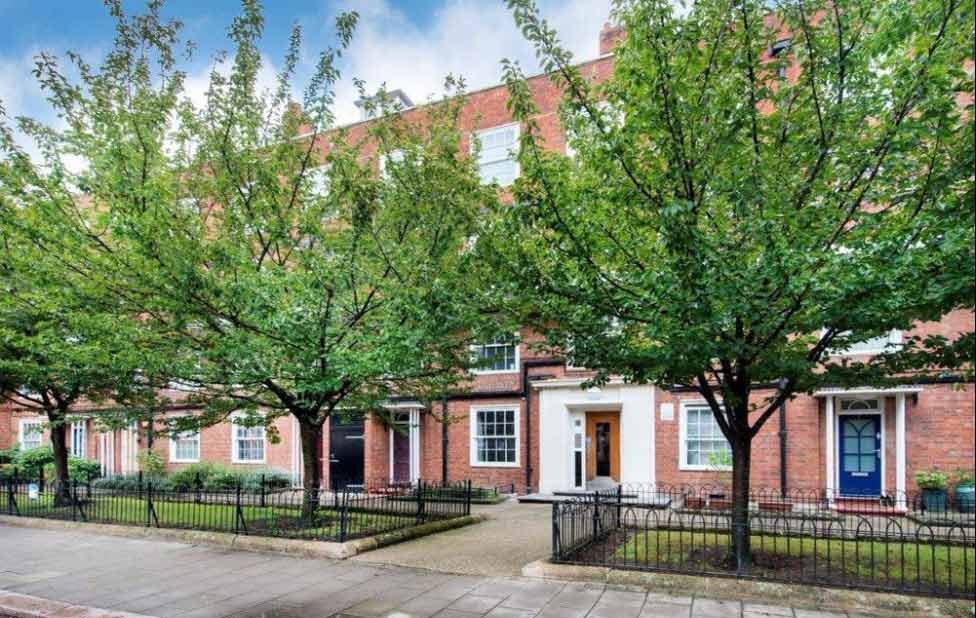 An apartment building with trees to the front