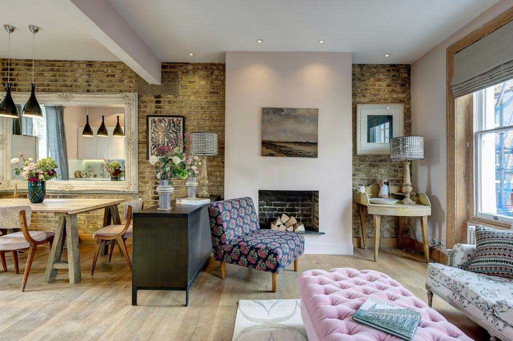 A bright lounge area with a brick wall and colourful furnishings
