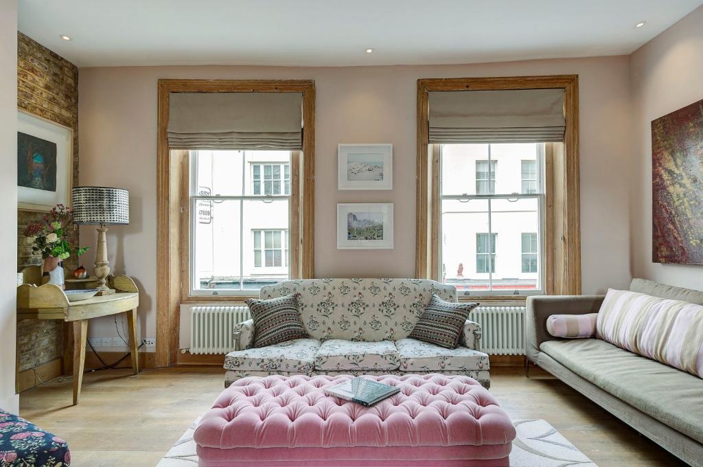 A bright lounge area with sash windows and colourful furnishings