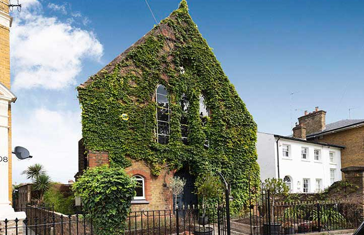 A church building with climbing plants, railings