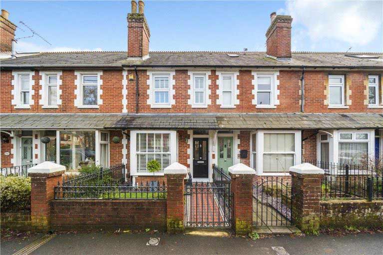 A row of terraced houses with sash windows, iron gates