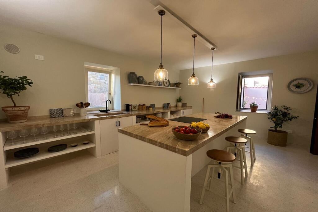 A kitchen with an island and pendant lights
