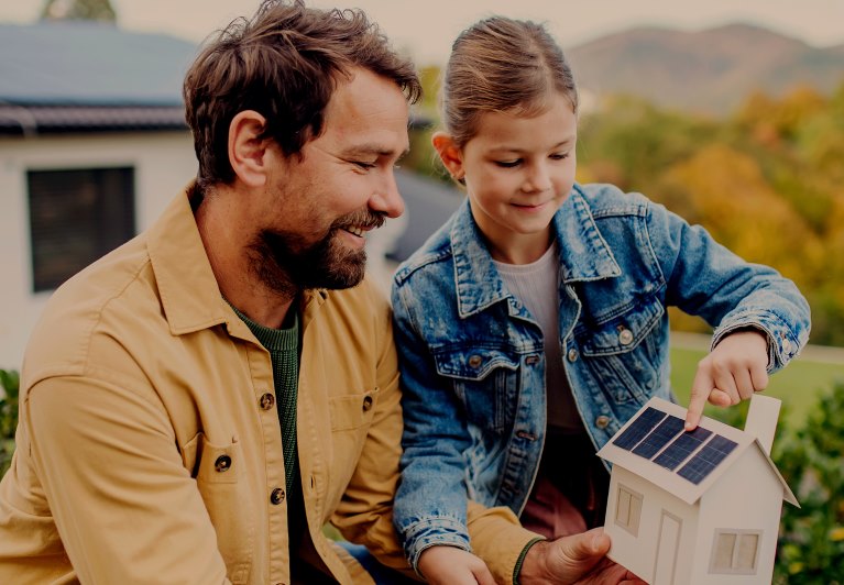 Two people looking at a model of a house