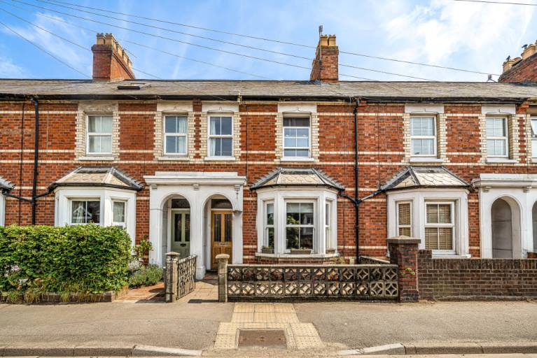 Red brick terraced houses with bay windows, blue sky