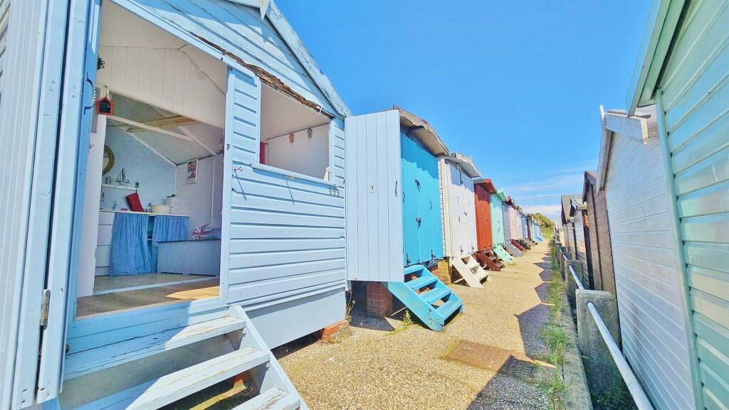 a line of five beach huts on Brighton promenade 5 beach huts are