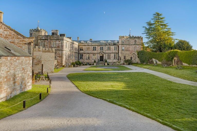 A castle with a lawn and driveway