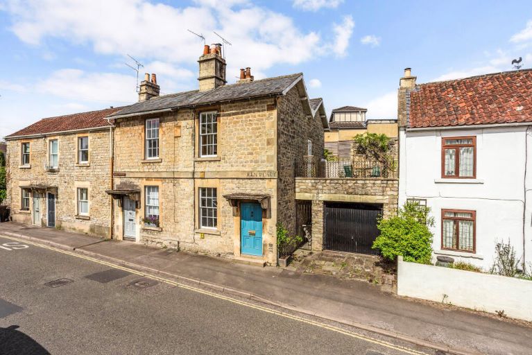 A row of stone cottages by a road