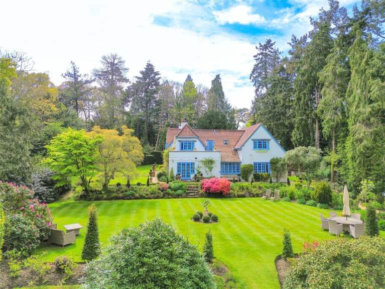 A blue and white house with a garden