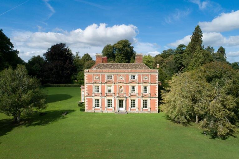 A manor house, lawns, trees, blue sky