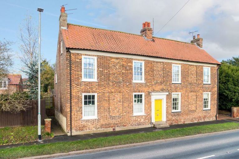 Detached red brick house, yellow door