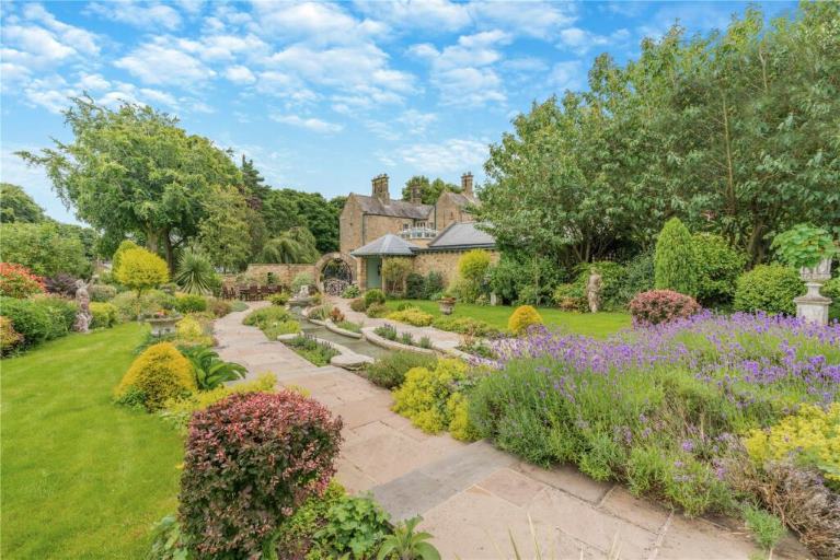 A detached with a landscaped garden, blue sky