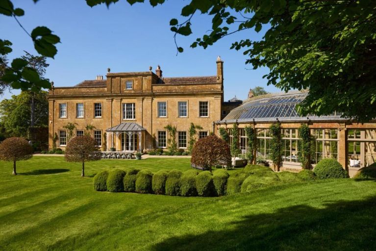A country manor, curved conservatory, a lawn