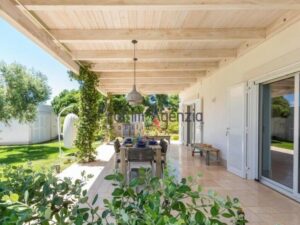 The outdoor seating area of a Brindisi home with green surroundings