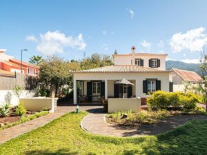 white villa with tiled roof and manicured garden