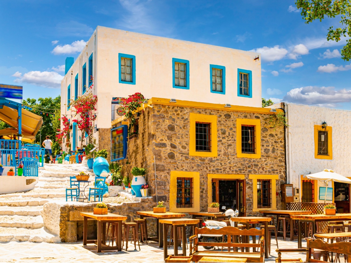 A stone home in Greece, on the Aegean Islands with chairs outside for outdoor dining